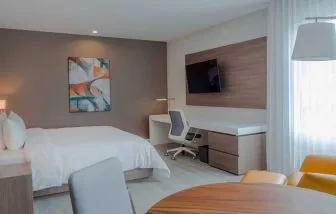luxurious king suite with TV, work desk, and dining area at Hilton Garden Inn Santa Ana San Jose.