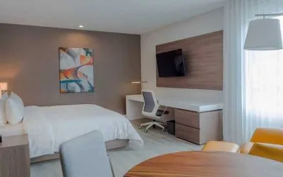luxurious king suite with TV, work desk, and dining area at Hilton Garden Inn Santa Ana San Jose.