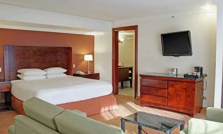 luxurious king suite with TV, work desk, and lounge area at DoubleTree by Hilton Hotel Cariari San Jose - Costa Rica.