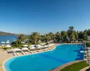 stunning outdoor pool surrounded by sun beds and pool umbrellas at DoubleTree by Hilton Bodrum Isil Club Resort.