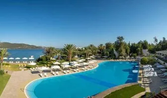 stunning outdoor pool surrounded by sun beds and pool umbrellas at DoubleTree by Hilton Bodrum Isil Club Resort.