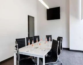 Small meeting room with TV screen at the Hampton Inn by Hilton Cancun Cumbres.