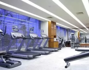well equipped fitness center with treadmills, bikes, and weights at Hilton Guangzhou Science City.