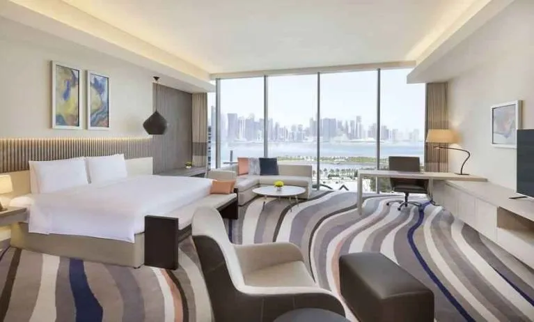 King suite with desk, sofa and TV screen at the DoubleTree by Hilton Doha - Old Town.