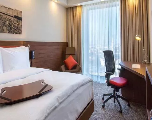 spacious king bedroom with TV, desk, chair, and couch at Hampton by Hilton Samsun.