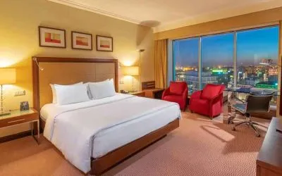King bedroom with desk along the window at the Hilton Warsaw City.