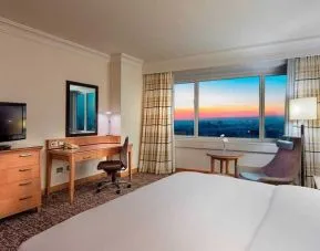 lovely king bedroom with TV, desk, and chair at Adana HiltonSA.
