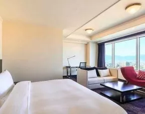 luxurious king suite with lounge area, business desk, and chair at Hilton Fukuoka Sea Hawk.