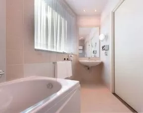 clean and spcious bathroom with bath and shower at Hilton Garden Inn Milan Malpensa.