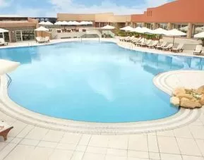 stunning outdoor pool with sunbeds and umbrellas at Hilton Alexandria Green Plaza.