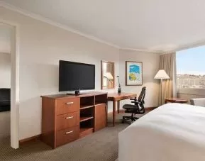 spacious king suite with TV, desk, chair, and couch at Hilton Colon Quito.