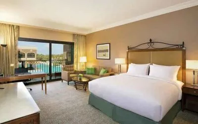 luxurious king room with TV, desk, chair, and lounge area at Hilton Alexandria King's Ranch.