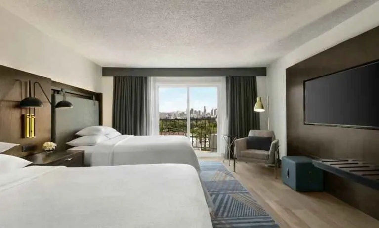 Double queen room with TV screen at the Embassy Suites by Hilton Los Angeles Downey.