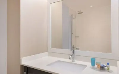 Spacious guest bathroom with shower at Courtyard By Marriott New York JFK Airport.