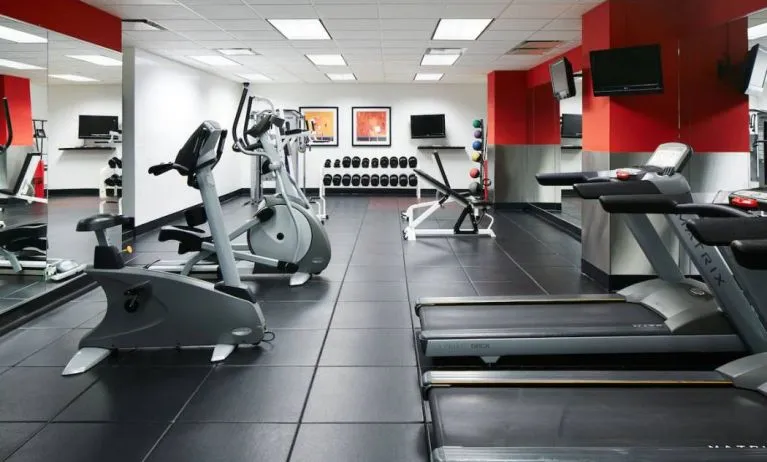 The hotel’s fitness center is equipped with multiple exercise machines, benches, and weights.