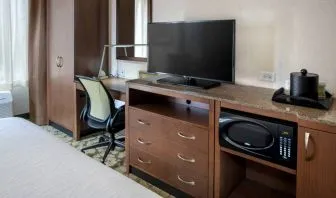 Closer view of an in-room workspace, with chair and desk for business, and both a lamp and window nearby.