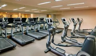 The hotel fitness center is equipped with numerous exercise machines for guests.