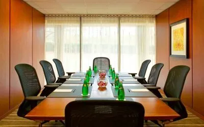 One of Westin Atlanta Airport Hotel’s meeting rooms, with long table, seating for eight, and a large window.