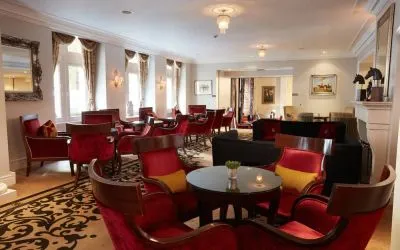 6 round tables with seating for 4-6 people decorate a cozy seating lounge.