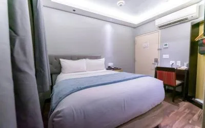 Madison LES Hotel room with double bed, and desk for working.