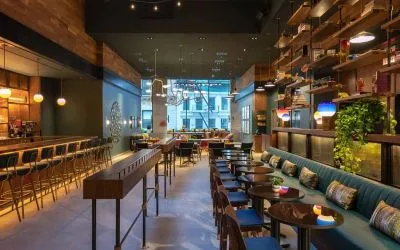 Moxy NYC Downtown’s Recreation restaurant, which has small tables and bar stool seating.