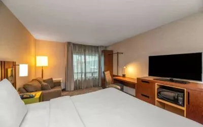 Double bed guest room in Comfort Inn Winnipeg Airport, with sofa and large window.