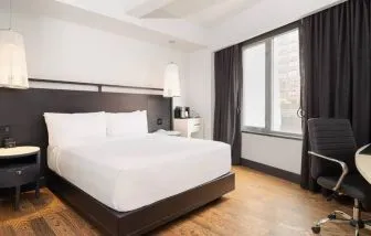 Guest room in the Hyatt Union Square New York, with large bed, window, and workspace.