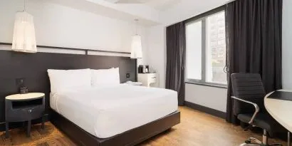 Guest room in the Hyatt Union Square New York, with large bed, window, and workspace.