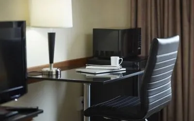An in-room workspace at the Comfort Inn Belleville, including desk, chair, and lamp.