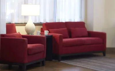 The hotel lobby lounge has comfortable seating and is brightly lit.