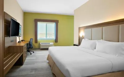 Comfortable king bedroom with TV and business desk at Holiday Inn Express & Suites Ontario.