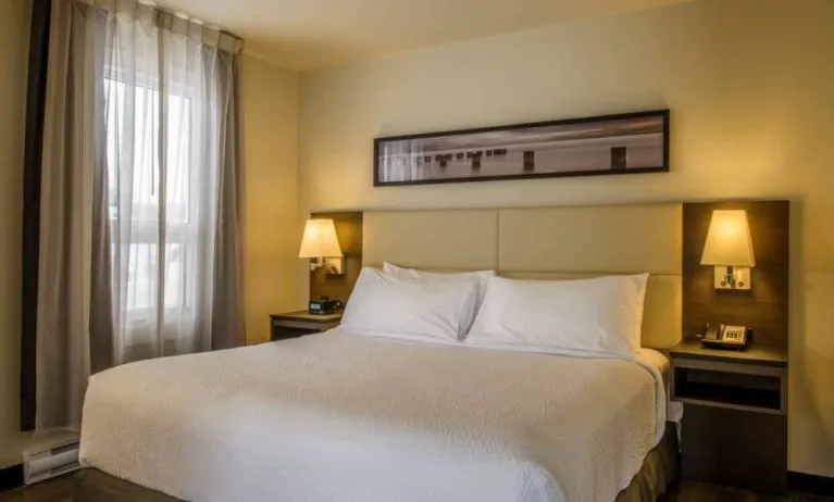 Double bed guest room in Rodd Miramichi River, with bedside lamps and nearby window.