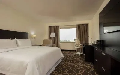 Delux king bed with TV and business desk at Doubletree By Hilton Toluca.