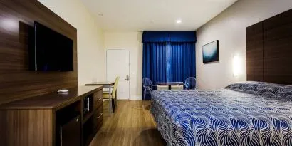 Day use room with dining table, work desk and TV at Palace Inn Blue Gessner.