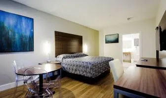 Day use room with dining table, work desk and TV at Palace Inn Blue Gessner.