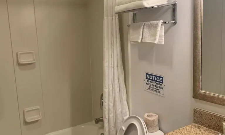 Guest bathroom with shower and tub at Sky Hotel Flushing - Laguardia Airport.