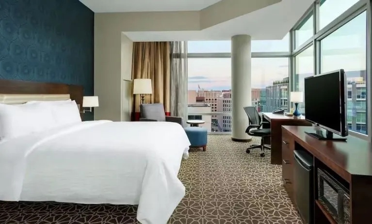 King bed with TV and natural light at Hilton Garden Inn Washington DC / Georgetown Area.