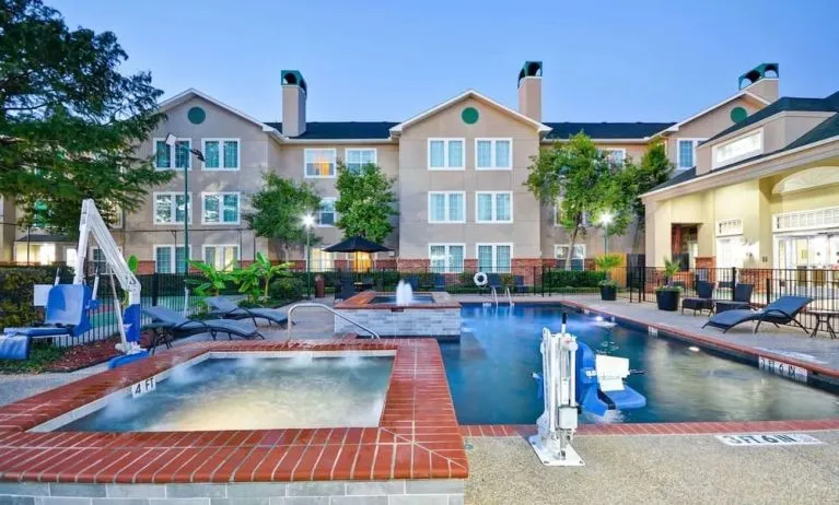 Luxurious pool area with jacuzzi hot tub at Homewood Suites By Hilton Dallas-Lewisville.