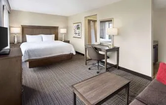 Day use room with work desk and sofa at Hampton Inn & Suites Alexandria.