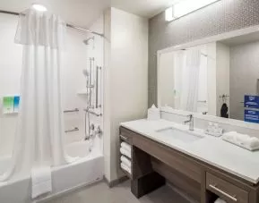 Private guest bathroom with shower and bath at Home2 Suites By Hilton Cape Canaveral Cruise Port.
