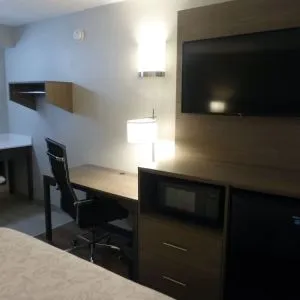 Day room with TV and work desk at Red Roof Plus Bourbonnais.