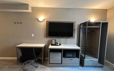 Dayroom with TV, mini-fridge, and work space at Regal Inn & Suites New York.