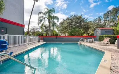 Outdoor pool with seating area at OYO Townhouse Orlando West.