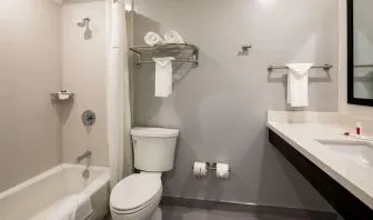 Private guest bathroom with combined shower and tub at Travelodge LAX By Wyndham.