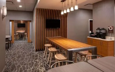 Sonesta Select Nashville Airport Suites meeting room, with long wooden table and a wall-mounted television.