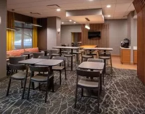 Hotel workspace, including extensive seating and tables for between two and six individuals, and coffee-making facilities.