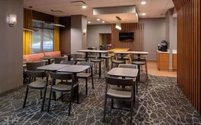 Hotel workspace, including extensive seating and tables for between two and six individuals, and coffee-making facilities.