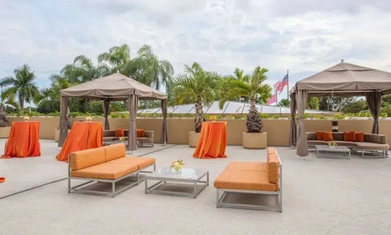 The hotel’s patio has comfortable sofa seating, coffee tables, and potted palm trees.