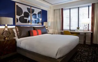 Royal Sonesta Washington DC Dupont Circle double bed guest room, featuring a window, and a workspace desk, chair, and lamp.