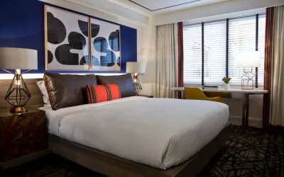 Royal Sonesta Washington DC Dupont Circle double bed guest room, featuring a window, and a workspace desk, chair, and lamp.